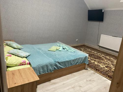 a bedroom with a bed with a blue blanket at Катерина in Chynadiyovo