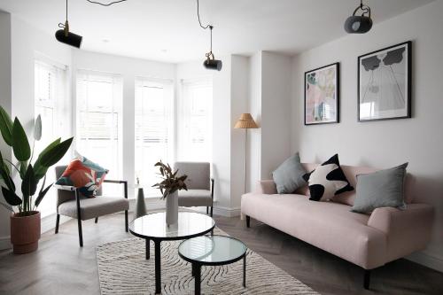 a living room with a couch and a table at Pinot Perch With Free Underground Parking in Whitby