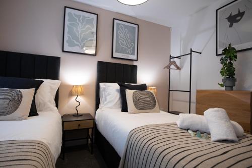 a bedroom with two beds and a table with a lamp at Pinot Perch in Whitby