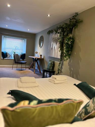 a bedroom with a large bed with plants on the wall at Stable Yard Rooms in Richmond
