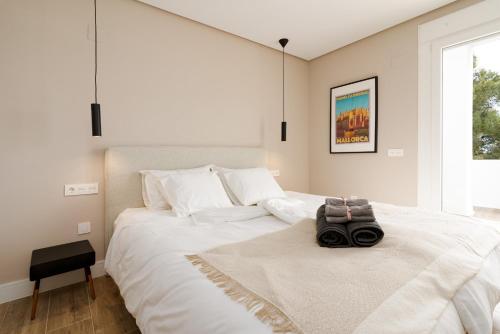Un dormitorio con una gran cama blanca con una cámara. en Golf Gardens Miraflores, en Mijas Costa