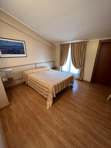 a hotel room with a bed and a large window at Hotel Cristoforo Colombo in Osimo