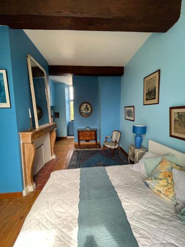 Les Loges-sur-Brécey的住宿－Bed&Breakfast au Château des Boulais，卧室拥有蓝色的墙壁和一张床