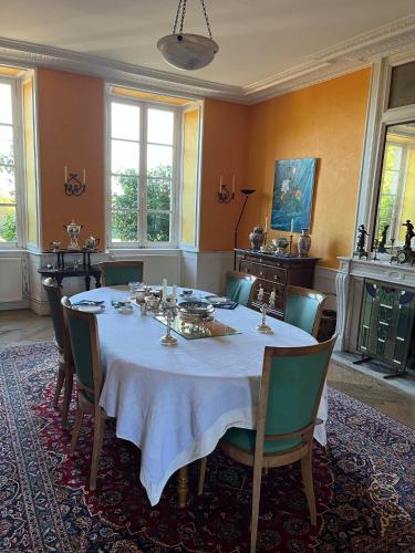 Les Loges-sur-Brécey的住宿－Bed&Breakfast au Château des Boulais，一间配备有白色桌椅的用餐室