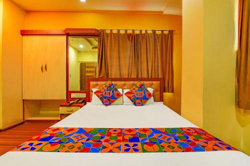 a bedroom with a bed with a colorful bedspread at FabHotel AG Star - Nr Kolkata Airport in kolkata