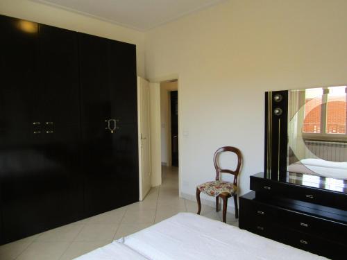 1 dormitorio con cama, silla y vestidor en Viareggio all seasons en Viareggio