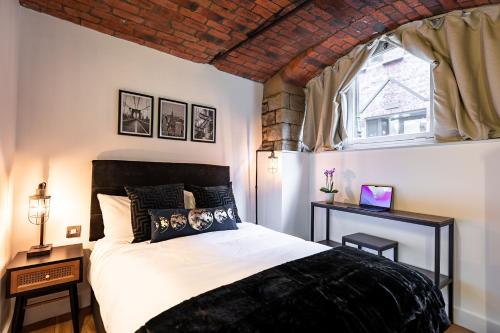 a bedroom with a black and white bed and a window at Mandega House in Sheffield