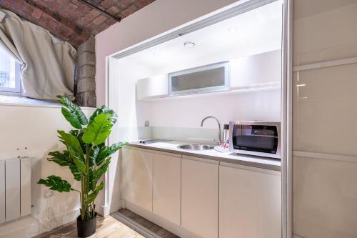 a kitchen with a sink and a microwave at Mandega House in Sheffield