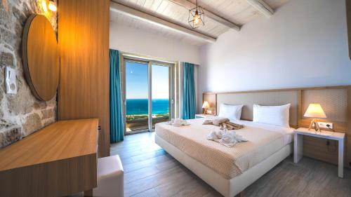 a bedroom with a bed with a view of the ocean at Nafsika Xenia - Ariti Villa in Plátanos