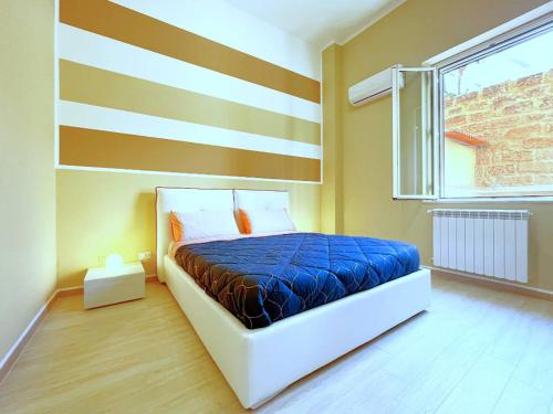 1 dormitorio con 1 cama con pared a rayas en Solemar Sicilia - Casa Valguarnera, en Bagheria