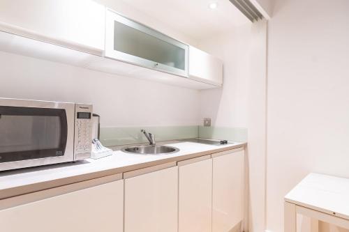 a kitchen with a microwave and a sink at Mandega House in Sheffield