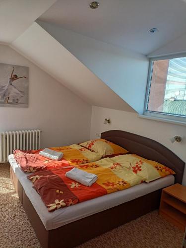 a bedroom with a bed in a attic at Apartmán Zlatá rybka in Podhájska
