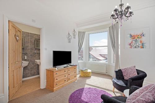 a living room with a television and a bathroom at White Rose Guest House in Filey