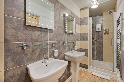 a bathroom with a sink and a toilet and a shower at White Rose Guest House in Filey