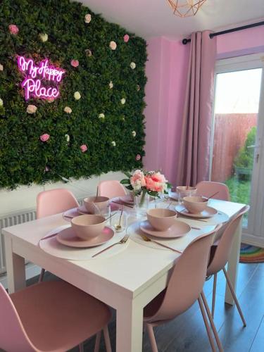 a white table with pink chairs and flowers on it at #1 Most Viral Pink House w Ball Pit in Liverpool