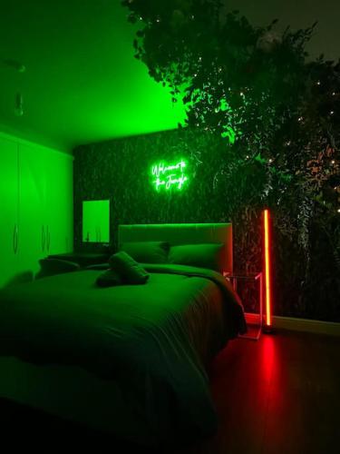 a green bedroom with a bed and a green light at #1 Most Viral Pink House w Ball Pit in Liverpool