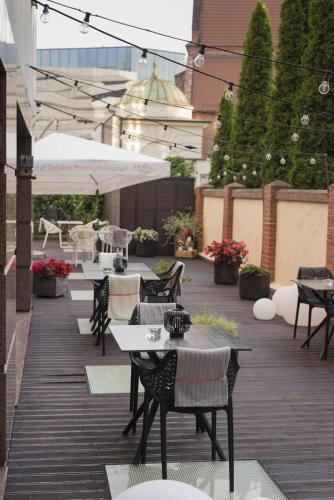 an outdoor patio with tables and chairs and umbrellas at Hotel DeSilva Premium Poznań in Poznań