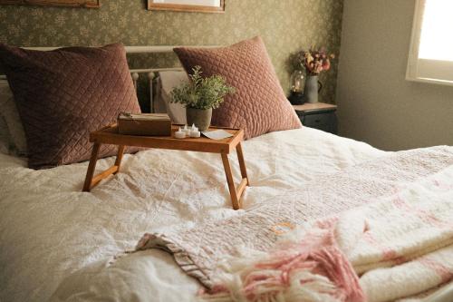 a bed with a table on top of it at The Romantic Pink English Cottage at Tamborine Mountain in Mount Tamborine