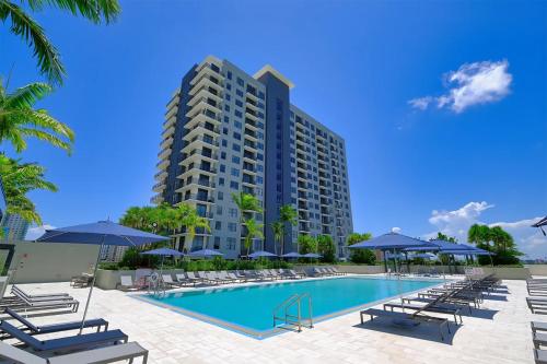 a large apartment building with a pool and lounge chairs at 3 Story Luxury Apt Las Olas FTL in Fort Lauderdale