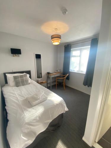a bedroom with a large white bed and a table at Bells Hotel in Coleford