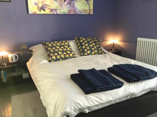 a bed with two towels on it with two lamps at The ArtWorks in Hastings