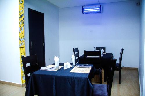 a blue dining room with a table and chairs at Hotel Capitol in Ikeja