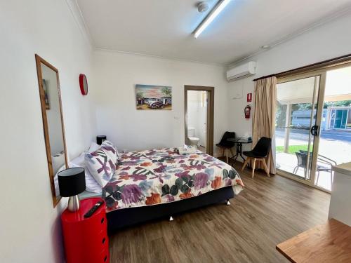 庫塔曼德拉的住宿－Cootamundra Caravan Park，一间卧室配有一张床和一张桌子及椅子