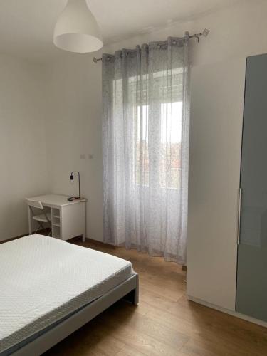 1 dormitorio con cama, escritorio y ventana en La Rossini, en Oristano
