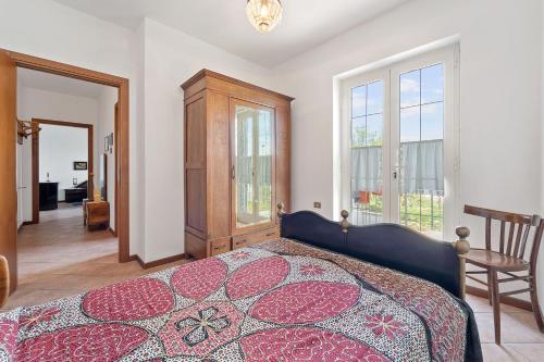 um quarto com uma cama, uma cadeira e janelas em Casa del vento 2 em Tratalias