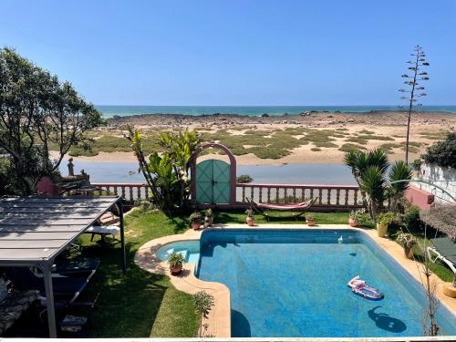 a swimming pool with a view of the beach at Aux Moules de Harhoura Rabat in El Harhoura