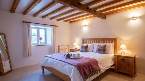 a bedroom with a bed and a window at Hope Cottage in Naunton