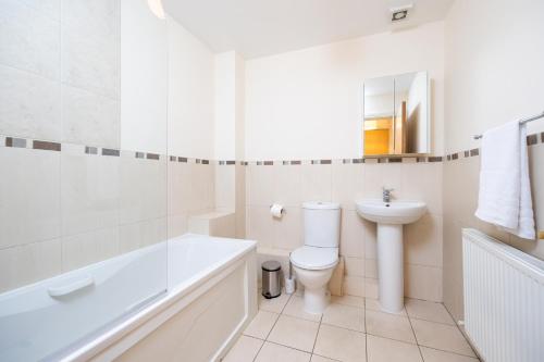 La salle de bains blanche est pourvue d'une baignoire, de toilettes et d'un lavabo. dans l'établissement Errigal House, Eglington Road, Donnybrook, Dublin 4 -By Resify, à Dublin