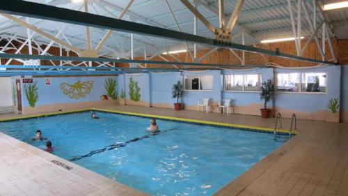 a large swimming pool with people in the water at 2 bedroom Chalet all to yourself, free parking, dogs welcome in Swansea