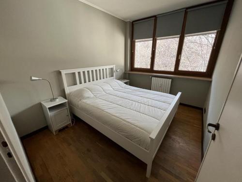 una camera con un letto bianco e due finestre di Ideale per due famiglie. Comodo a centro e piste a Bardonecchia