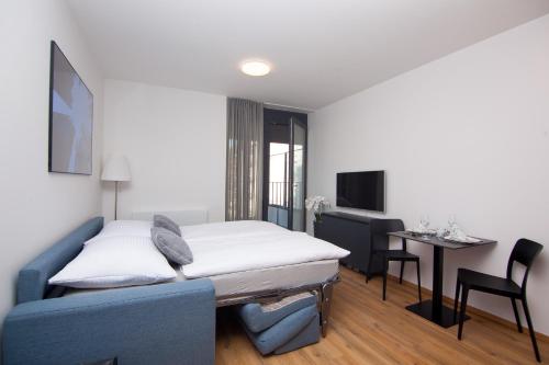 sala de estar con cama, mesa y sillas en Apartmány Viviena en Brno