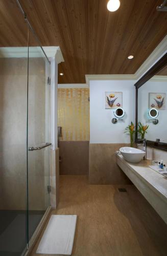 a bathroom with a glass shower and a sink at Radisson Blu Resort, Goa in Cavelossim