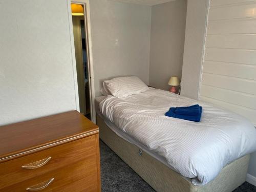 a small bedroom with a bed and a wooden dresser at 2 Bedroom Ground Floor Holiday Apartment Skegness in Skegness