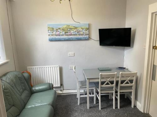 a living room with a table and a couch and a television at 2 Bedroom Ground Floor Holiday Apartment Skegness in Skegness