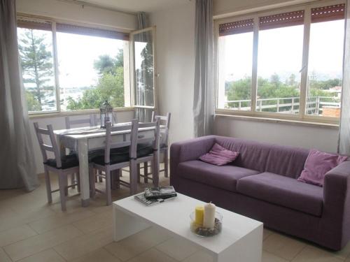 a living room with a purple couch and a table at Orizzonte Mare in Fontane Bianche