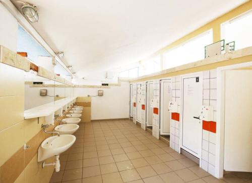 a bathroom with a row of sinks and toilets at Adria Caravan (with air conditioner) in Privlaka