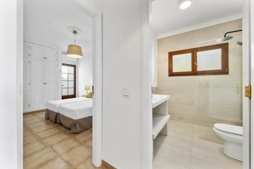 a bedroom with a bed and a toilet and a sink at Villa 22 in Tías