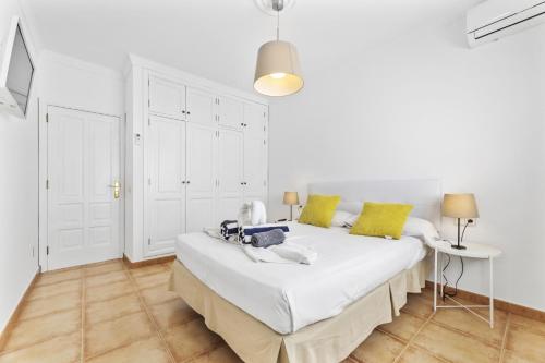 a white bedroom with a bed and a table at Villa 22 in Tías