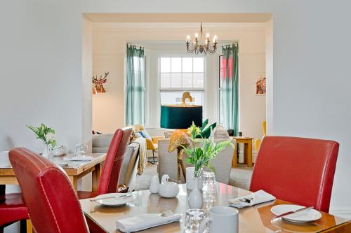 a dining room with a table and red chairs at White Rose Guest House in Filey