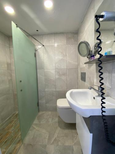 a bathroom with a sink and a toilet and a mirror at Gala Otel Edirne in Edirne