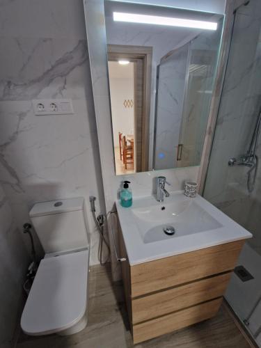 łazienka z umywalką, toaletą i lustrem w obiekcie Schöne Ferienwohnung ca. 350m vom Strand entfernt w mieście Oropesa del Mar