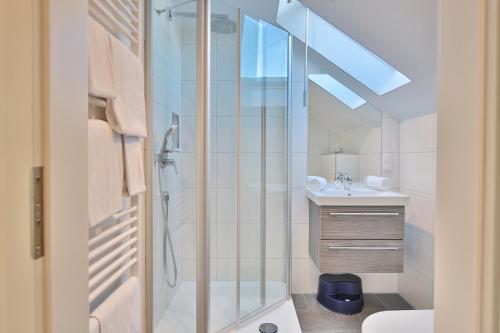 La salle de bains est pourvue d'une douche et d'un lavabo. dans l'établissement Appartemenhaus Linda-Lu Appartementhaus Linda-Lu Appartement 8, à Scharbeutz