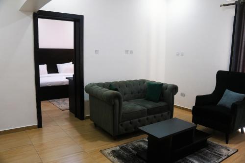 a living room with a couch and a mirror at Hotel Capitol in Ikeja