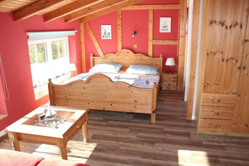 a bedroom with a wooden bed and a table at Oberdeck in Dierhagen