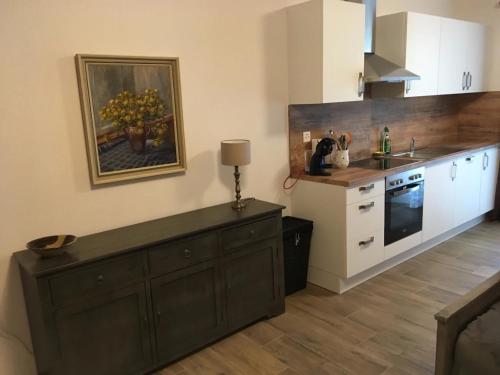 uma cozinha com um armário de madeira escura numa cozinha em Vacances à la Ferme des Buffles em Travers