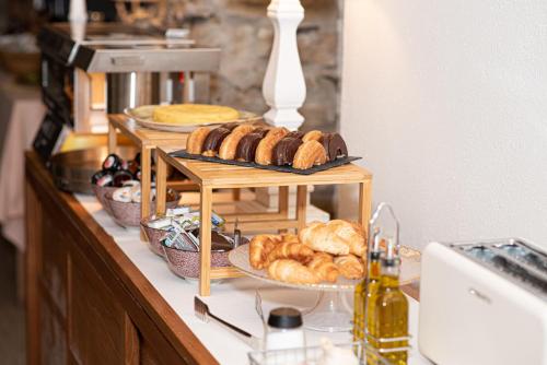 a buffet with various types of bread and pastries at El Petit Convent in Begur